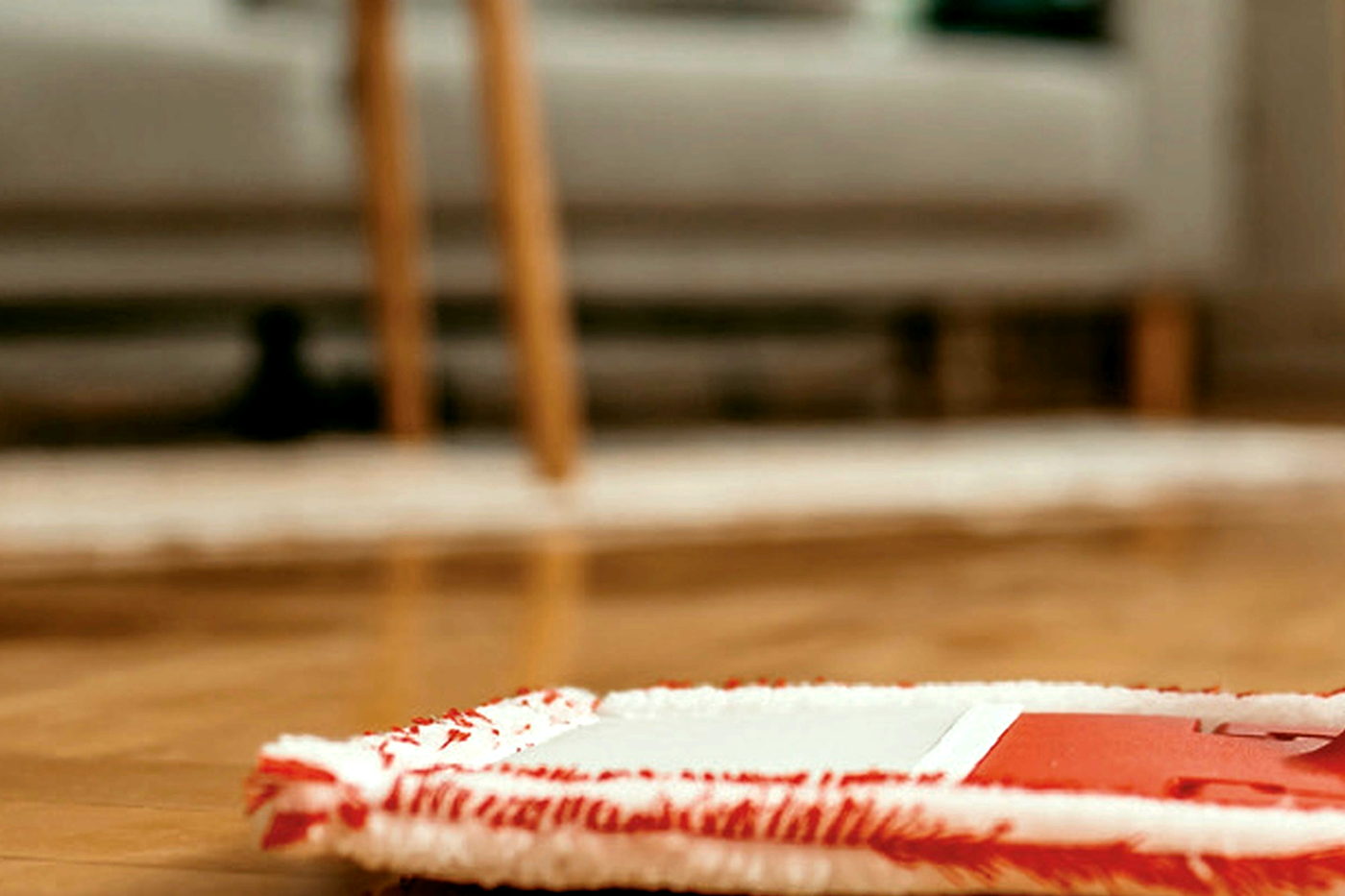 A wooden floor being mopped in a bright living room